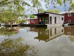 a house on the water next to a river at Hausboot Stöckte in Winsen