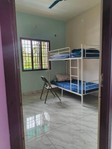 a room with two bunk beds and a chair at Sunrise Strength Club in Villupuram