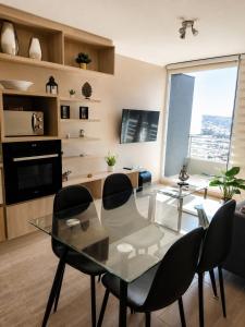 a dining room with a glass table and chairs at Ale Canal Beagle in Viña del Mar