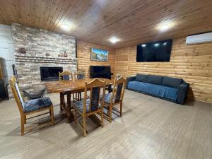 a living room with a table and a blue couch at Міні-готель На Росі in Steblëv