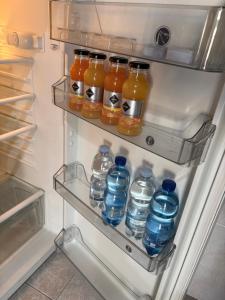 a refrigerator filled with bottles of water and juice at Aperto Tuscany apartment in Torrenieri +10 photos