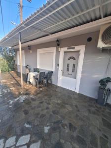 a patio with a table and a white house at Eva's house in Xanthi