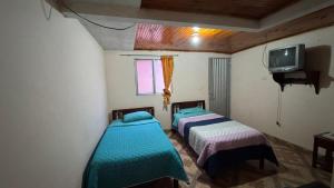 two beds in a small room with a tv and a tv at Hotel Casaloma in Florián +38 photos