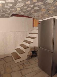 a kitchen with a staircase in the wall with a refrigerator at Roubenka Skalnička in Adršpach