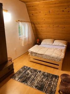a bedroom with a bed in a wooden room at Pogórzański Domek in Ciężkowice