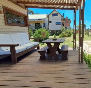 a wooden deck with a couch and a table at Villa Gutierrez4 in Punta Del Diablo