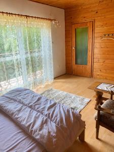 a bedroom with a bed and a large window at Pogórzański Domek in Ciężkowice