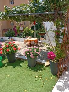 a garden with pots of flowers and a table and chairs at LOUKIA'S HOUSE in Skala Kallirachis