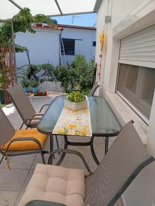 a glass table and chairs on a patio at LOUKIA'S HOUSE in Skala Kallirachis