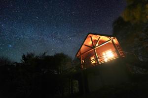 a room with a lit up window at night at ログハウス SakuraFamiliar in Kawazu