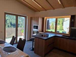 a room with a kitchen with a desk and a television at Residence Wiesenheim in Trodena