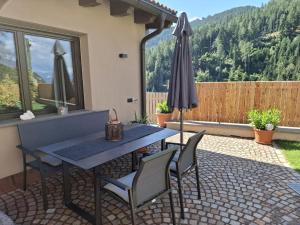 a patio with a table and chairs and an umbrella at Residence Wiesenheim in Trodena