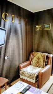 a chair in a room with a striped wall at Небольшая СТУДИЯ, проспект ЦЕНТРАЛЬНЫЙ 124А, 2 дивана, 2 кресла 3 этаж 9 этажного дома Wi-Fi in Mykolaiv