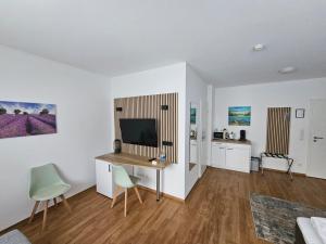 a living room with a desk and a television at Hotel Am Wintergarten in Bocholt