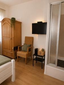 a living room with a bed and a chair at Guesthouse - Weeze Rooms in Weeze