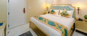 a bedroom with a large bed with a blue headboard at Studio by Jardin in Indore