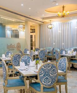 a dining room with blue and white chairs and tables at Studio by Jardin in Indore