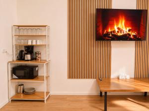 a living room with a fireplace with a tv on the wall at City Line Koblenz in Koblenz