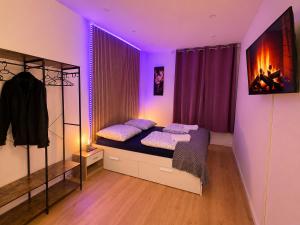 a bedroom with a bed with purple lighting at City Line Koblenz in Koblenz