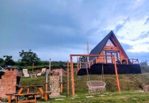 a house with a playground and a swing at Cabana A-frame City View Târgoviște in Valea Voievoziilor