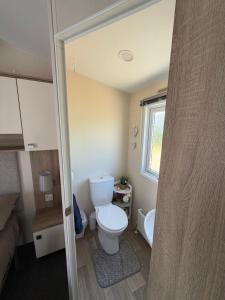 a small bathroom with a toilet and a window at Teal - a few steps from the beach in Redcar +43 photos