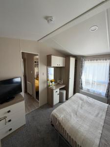 a bedroom with a bed and a flat screen tv at Teal - a few steps from the beach in Redcar