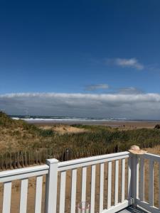 a view of the beach from a white fence at Teal - a few steps from the beach in Redcar