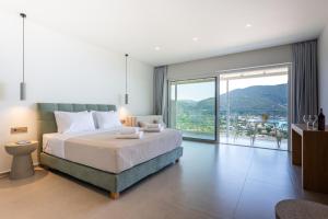 a bedroom with a large bed and a large window at Zofeni in Póndi +57 photos
