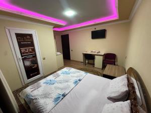 a room with a bed and a table with a tv at Elit Hotel in Mingachevir