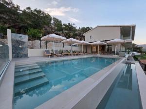 a swimming pool with chairs and umbrellas at Zofeni in Póndi