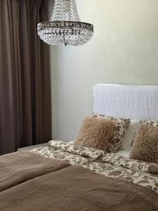 a bedroom with a bed with a chandelier at Villa Lydia Lapland - Private Sauna & Aurora View in Rovaniemi