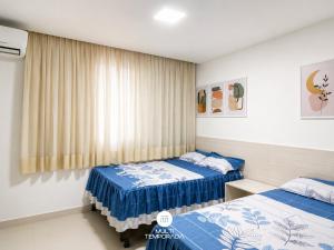 a bedroom with two beds and a window at Casa Ilha do Sol - Vera Cruz/BA in Vera Cruz de Itaparica