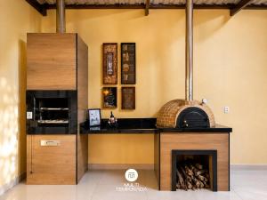 a kitchen with a stove and a fireplace at Casa Ilha do Sol - Vera Cruz/BA in Vera Cruz de Itaparica +23 photos