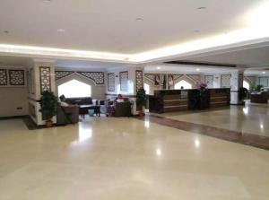 a lobby of a hotel with a person sitting on a couch at فندق نمبر وان 3 in Al Masfalah
