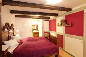 a bedroom with a red bed and a red wall at Babette Apartments in Lübeck