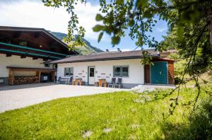 a house with a green door and a yard at Chalet 3 Musketiers in Viehhofen