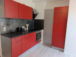 a kitchen with red cabinets and a stove at Crew Base Zeltweg in Zeltweg