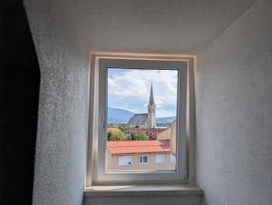 a window in a room with a view of a church at Crew Base Zeltweg in Zeltweg