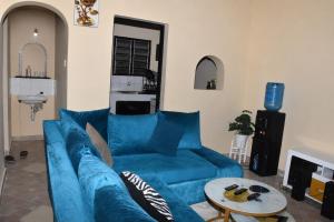 a blue couch in a living room with a table at Maya Comforts in Ukunda
