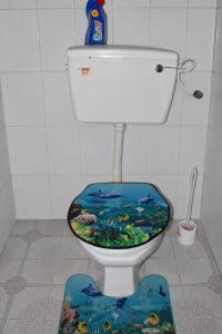 a toilet with a fish themed seat in a bathroom at Maya Comforts in Ukunda +2 photos