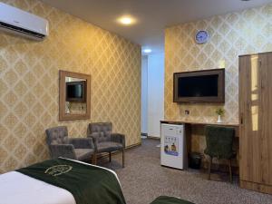 a hotel room with a bed and a flat screen tv at Modern Palace Hotel in Al Fayşalīyah