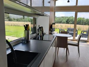 a kitchen with a counter and a table with chairs at Domki nad Grabią in Rokitnica