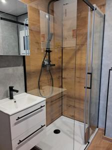 a bathroom with a shower and a sink at Domki nad Grabią in Rokitnica +12 photos