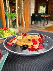 a plate of food with fruit on a table at Nota Bene Pokoje Gościnne Polanica Zdrój in Polanica-Zdrój