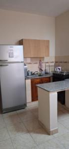 a kitchen with a white refrigerator and a counter at Ciudad de Nieva a pasos de Ciudad Cultural in San Salvador de Jujuy