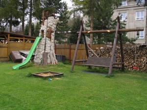 a park with a playground with a swing at Penzion u Antošů in Jeseník