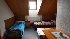 a room with two beds and a table at Penzion u Antošů in Jeseník