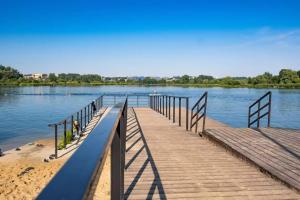 a dock on a lake with a boat in the water at Boho Quiet Studio Kraków in Krakow +5 photos