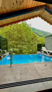 a swimming pool with a bench and a chair at Waterfall suit bungalov in Çamlıhemşin