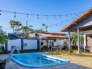 a pool in a backyard with a table and an umbrella at HOSTEL QUINTAL GUEST - Guarujá in Guarujá